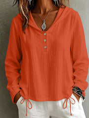 Front view of the coral hooded blouse with button placket and drawstring hem.