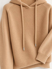 Light tan sweater close-up showing drawstrings, ribbed cuff and textured knit.