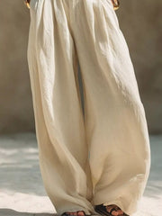 Close view of flowing cream wide-leg pants and gathered elastic waistband