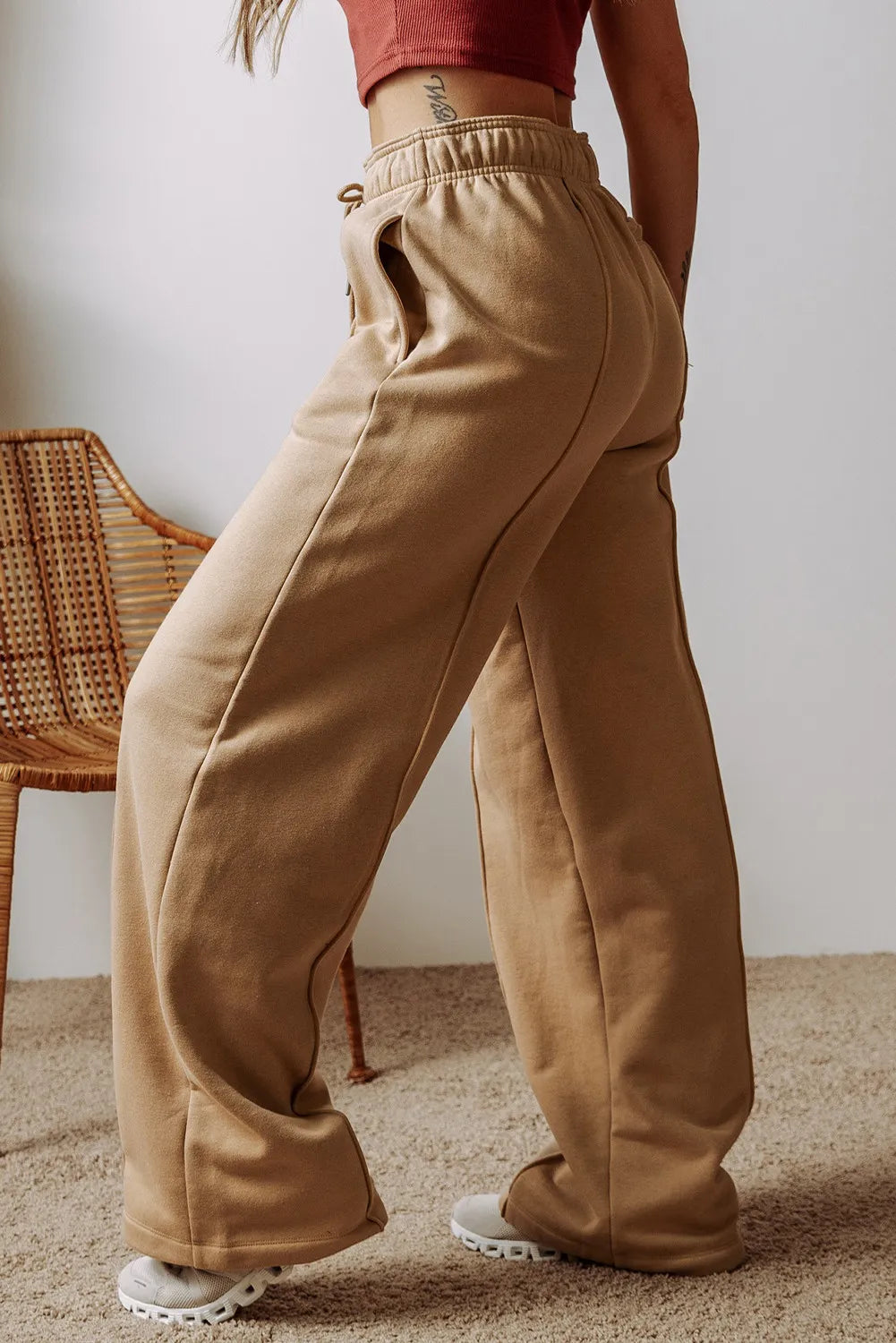 Side view of tan wide-leg drawstring pants with a relaxed fit.