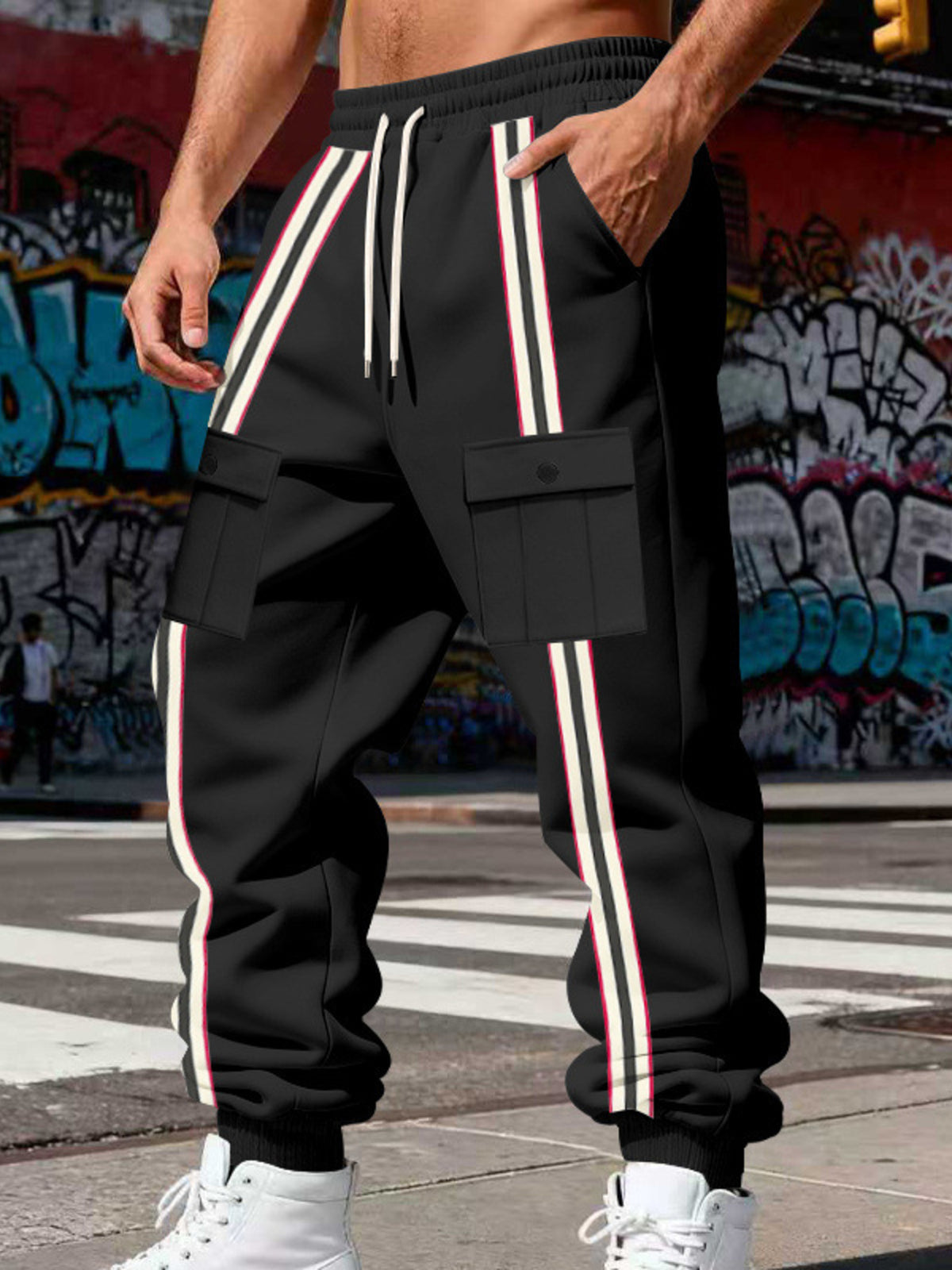 Close view of the black joggers' cargo pockets and vertical stripes
