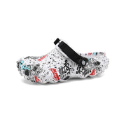 Angled view of a white graffiti-print clog showing rounded toe and sculpted sole
