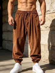Front view of rust brown corduroy joggers with drawstring waist and gathered ankle cuffs