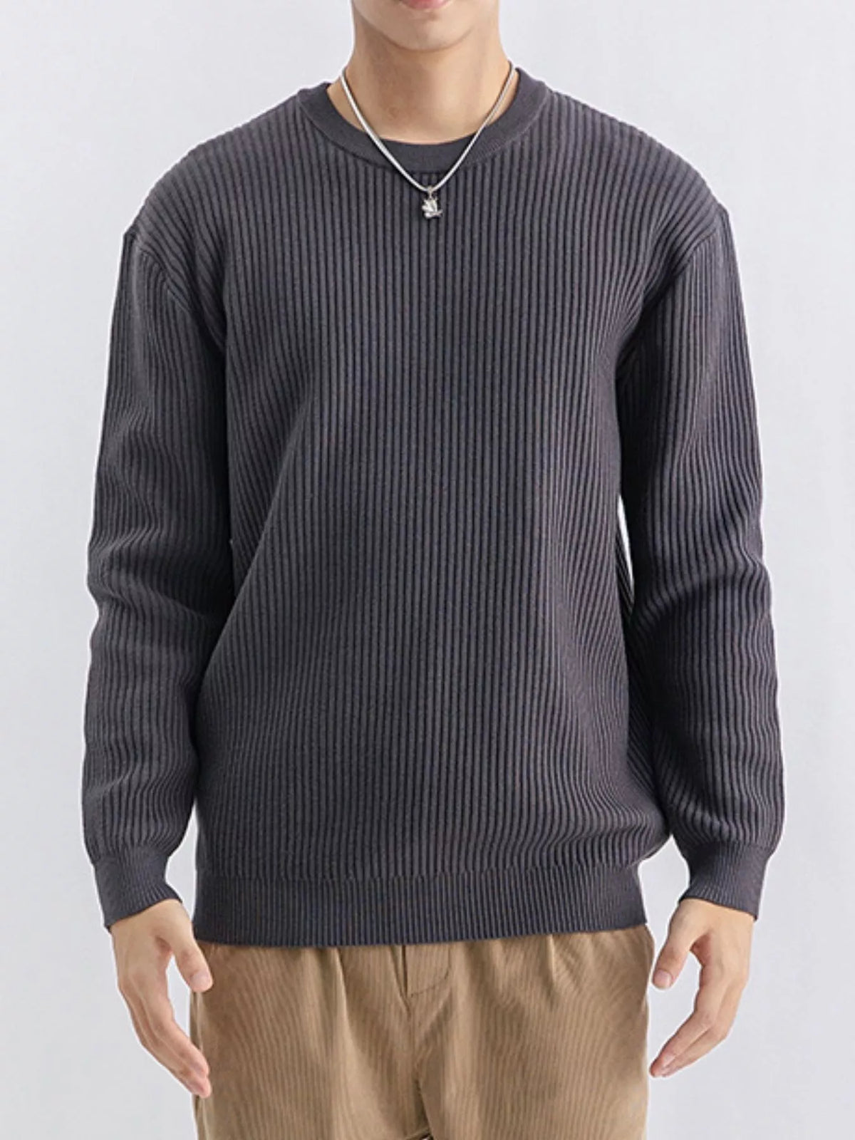 Charcoal grey ribbed sweater shown from the front with tan trousers