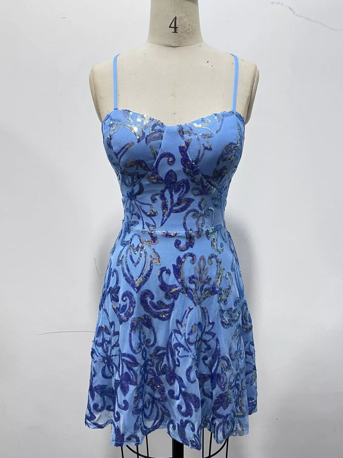 Light blue floral-sequin mini dress displayed on a dress form.