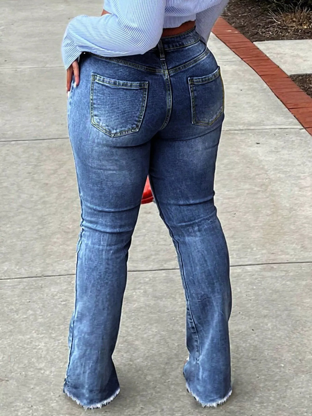 Back view of dark blue flare jeans showing the pockets and full-length legs.
