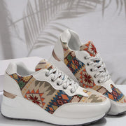 Pair of cream sneakers with multicolor patterned sides displayed on white background