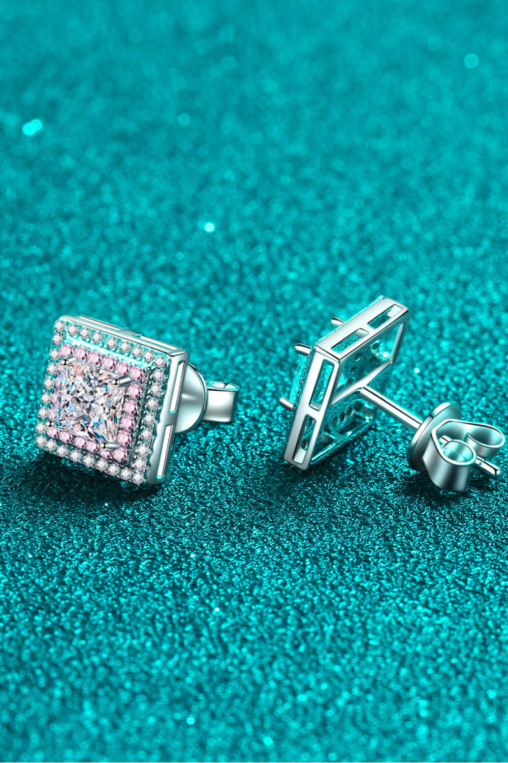 Square stone stud and post backs shown on teal surface