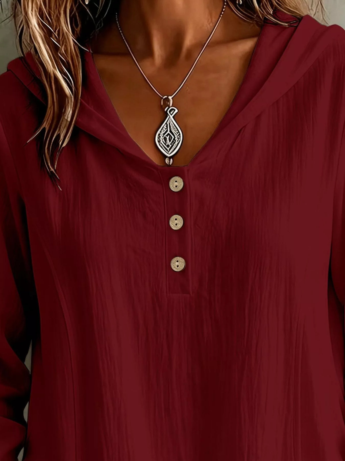 Close-up of the burgundy blouse neckline and button placket.
