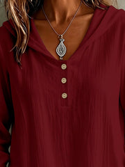 Close-up of the burgundy blouse neckline and button placket.