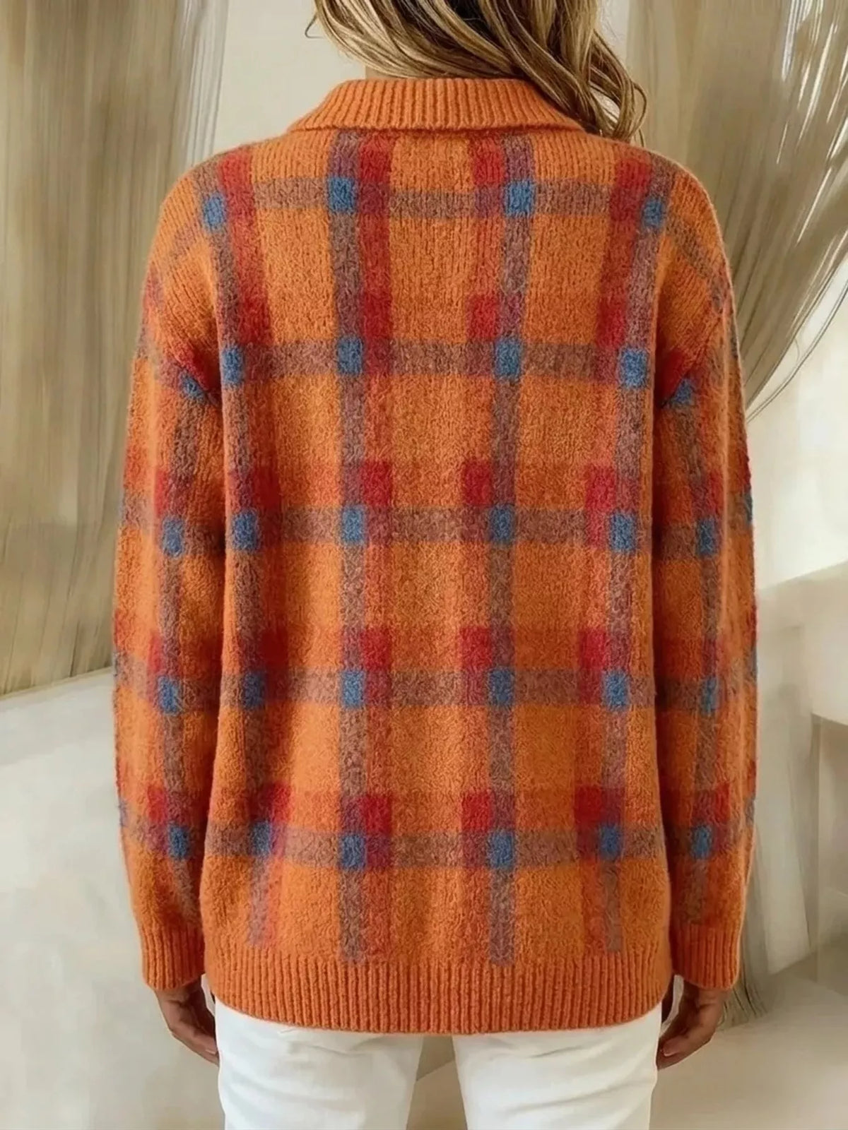 Back view of an orange and rust plaid cardigan with ribbed cuffs and hem.