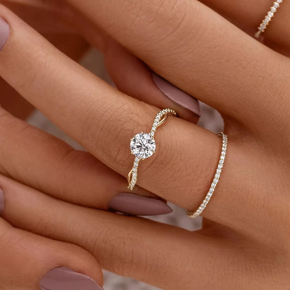 Round solitaire zircon ring on a slender silver-tone band worn beside a pavé band