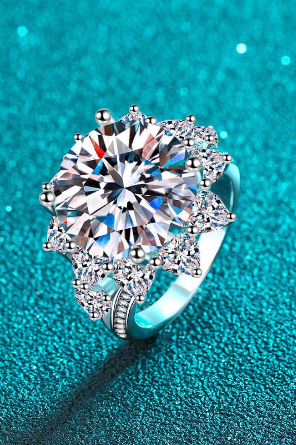 Flower-shaped moissanite ring shown against a turquoise background