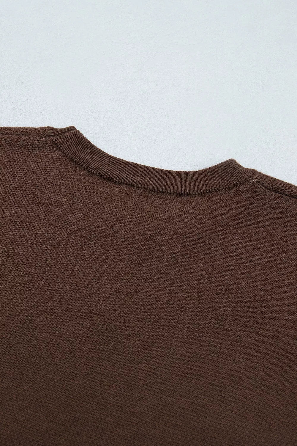 Close-up of plain brown tee back neckline and neck seam