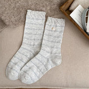 Close view of ribbed white knit socks with thin gray bands