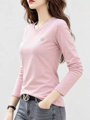 Pink long-sleeve crewneck T-shirt on a model, viewed from the front at an angle.