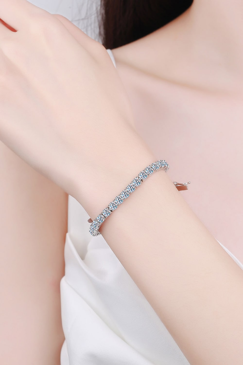 Silver moissanite bracelet worn around a wrist, shown against a pale background.
