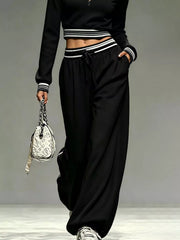 Black matching pants and cropped top, front view with hands in pockets