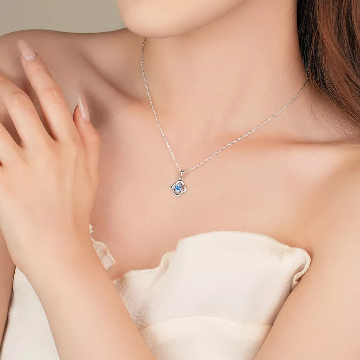 Light blue four-leaf clover pendant necklace worn at the collarbone