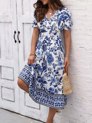 Angled view of the blue and white floral midi dress showing the puff sleeve and patterned hem.