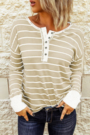 Model wearing beige and white striped Henley with white cuffs