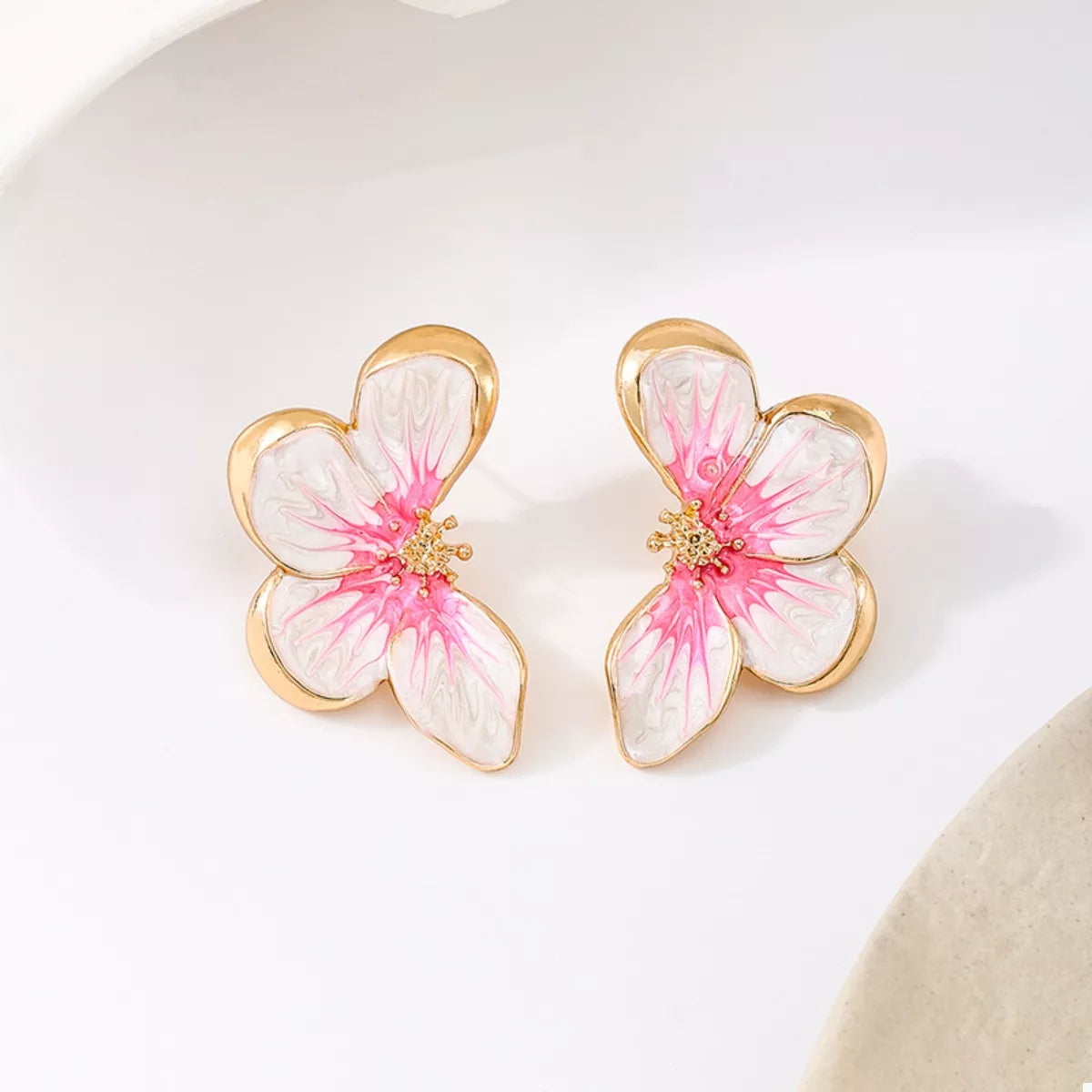 Pair of pink-and-white flower stud earrings, front view