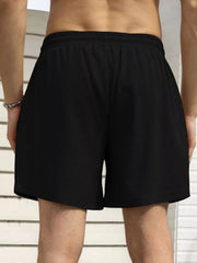 Model wearing black drawstring shorts, back view