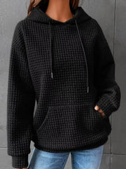 Black textured kangaroo-pocket hoodie worn with jeans
