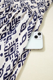 Close-up of printed fabric beside a phone for scale