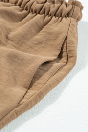 Close-up of the elastic drawstring waistband on tan utility trousers