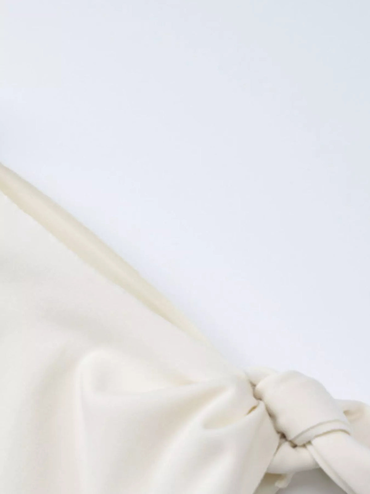 Close-up of ivory dress tie and draping