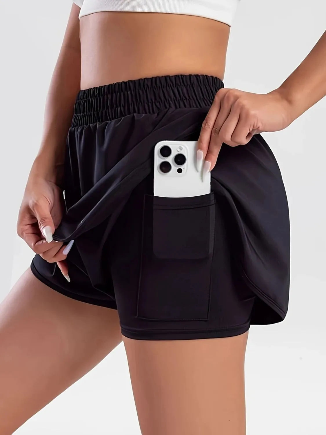 Close view of black running shorts with phone in rectangular pocket