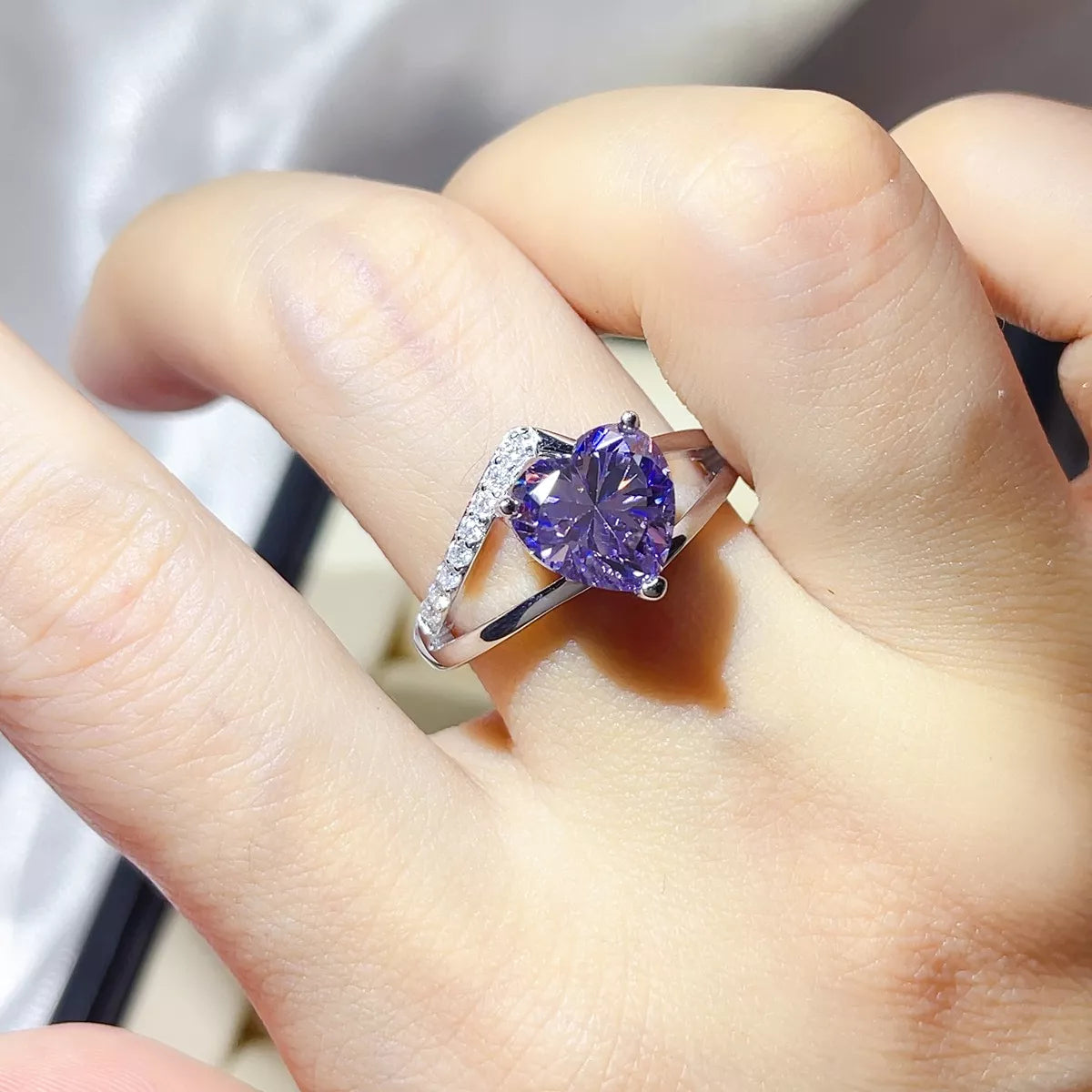 Close-up of the blue-purple moissanite centre stone and silver band