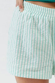 Mint green striped shorts showing gathered waistband and button placket
