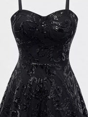 Close-up of the black dress's sweetheart bodice, floral sequins and waist seam.