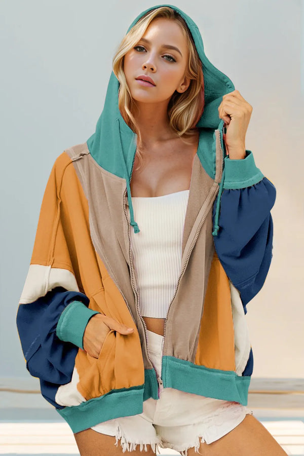 Color-block zip-up hoodie in peach, pink, and teal worn open over a white top.