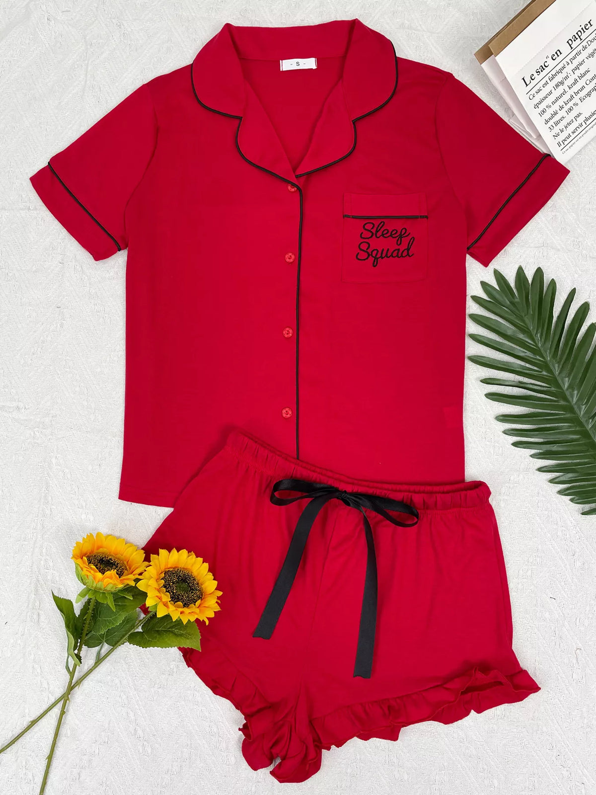 Red button-down pajama set with black piping and matching ruffle shorts, front view