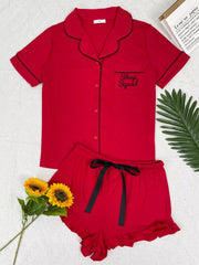 Red button-down pajama set with black piping and matching ruffle shorts, front view