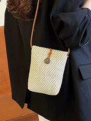 Off-white woven-texture crossbody bag worn at the side with long brown strap