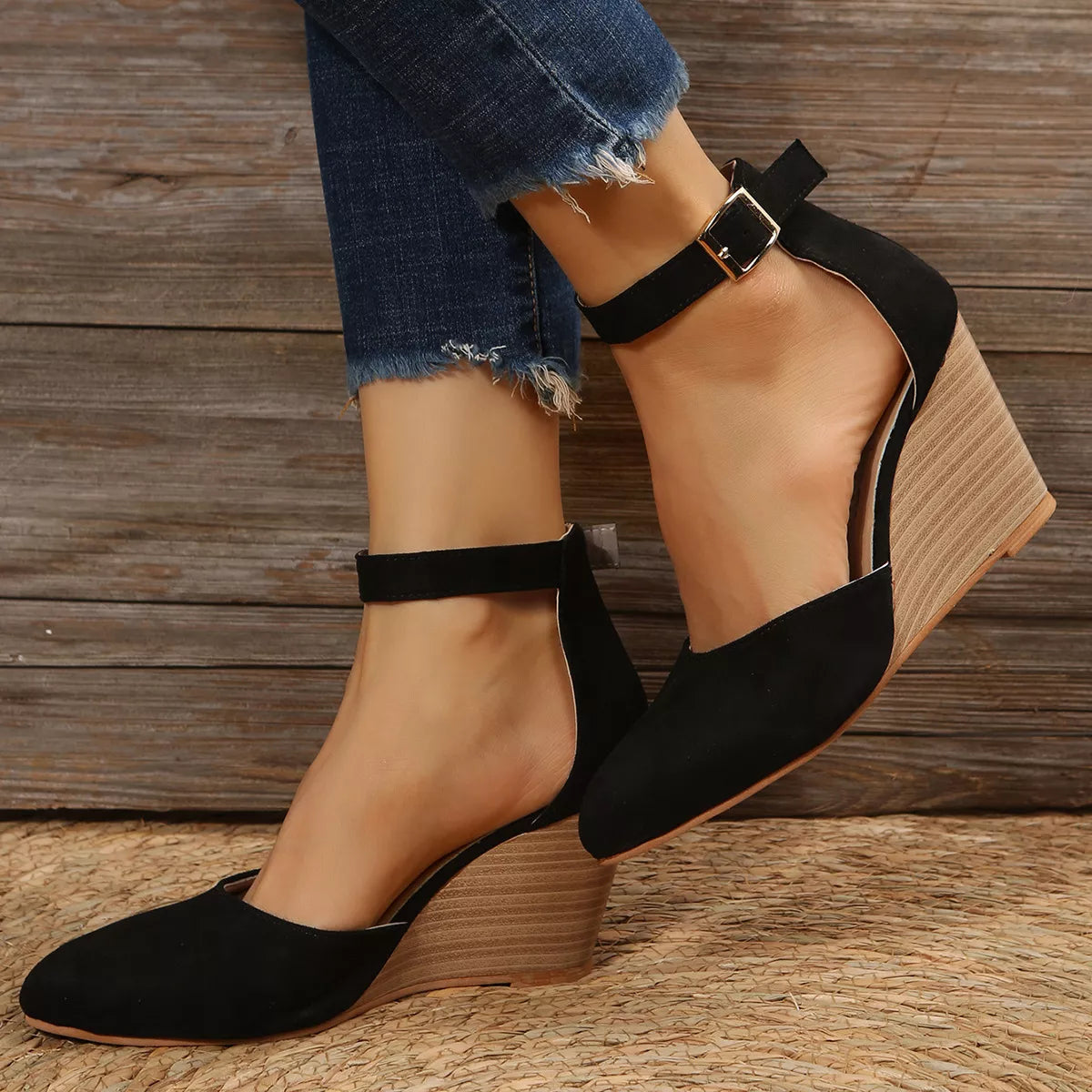 Black pointed-toe wedge sandals worn with ankle straps