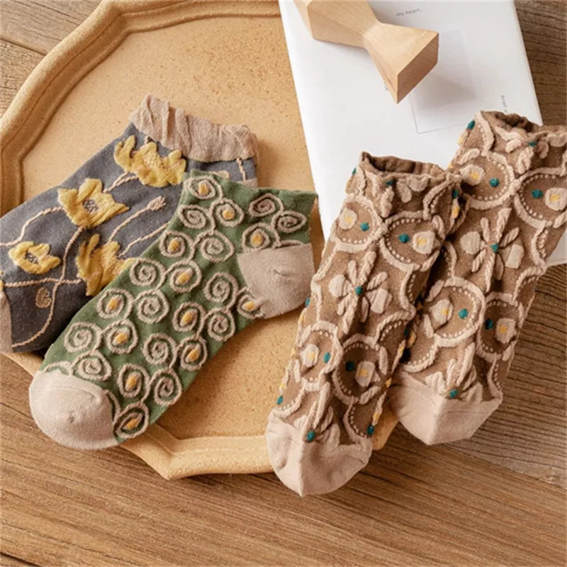 Grey yellow-flower, green spiral and brown floral ankle socks arranged together