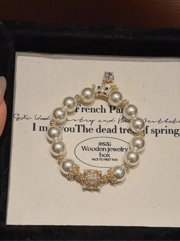 Gold-tone pearl bracelet displayed in its presentation box