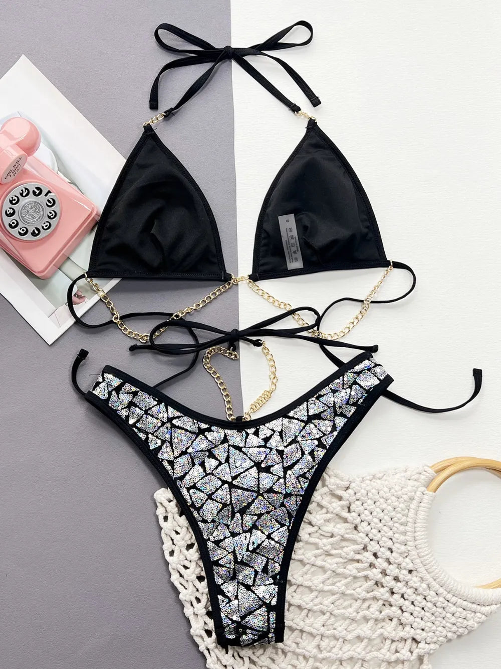 Silver sequin bikini laid flat showing black cup lining and gold-coloured chain details