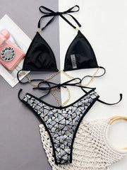 Silver sequin bikini laid flat showing black cup lining and gold-coloured chain details
