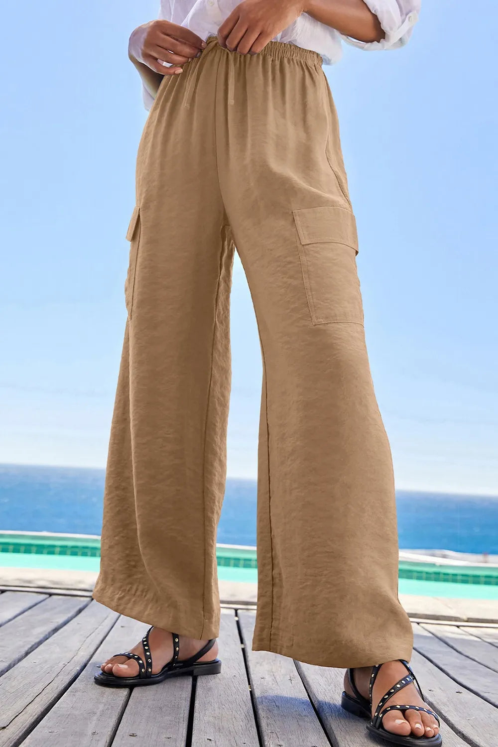 Tan utility trousers shown from the front with a relaxed wide-leg fit
