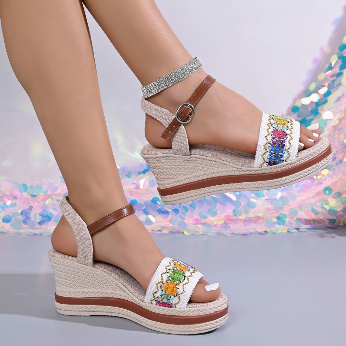 Close view of embroidered floral strap on an open-toe wedge sandal
