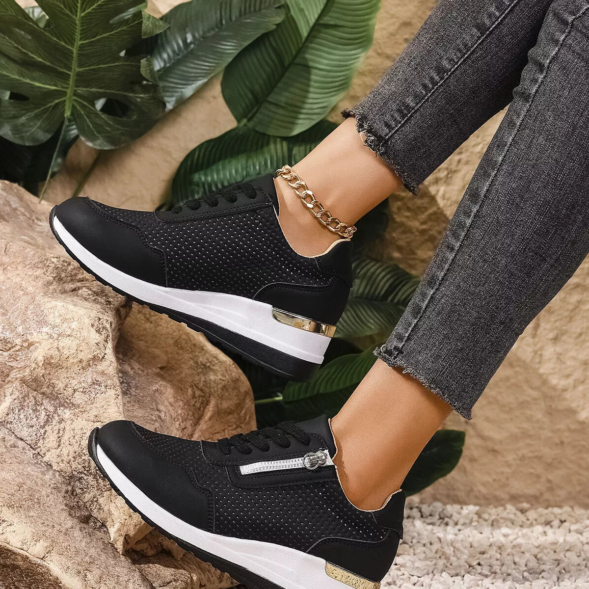 Side view of black knit sneakers with white wedge soles worn outdoors