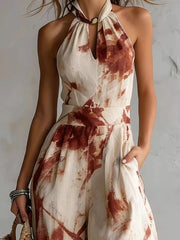Close-up of the rust-print jumpsuit's halter neckline, keyhole opening and fitted waist.