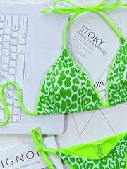 Neon-green-trim leopard bikini set laid flat on display