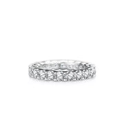 Close-up of the pink center stone and pavé-set shoulders on a silver ring displayed over a turquoise ribbon.